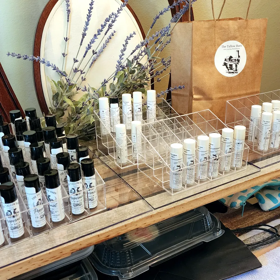 Rows of lip balm tubes arranged in clear countertop holders.