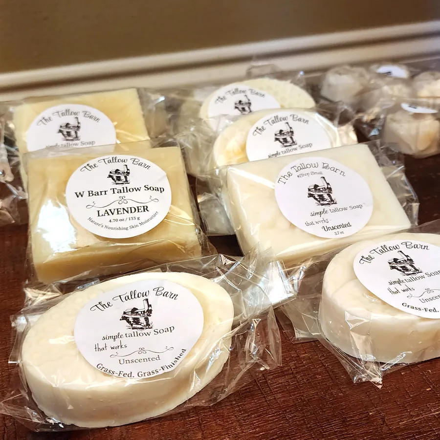 Individually wrapped The Tallow Barn soap bars on a wooden display table.